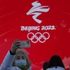 Une femme se prend en photo devant le logo des Jeux de Pékin.