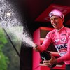 Le Slovène Tadej Pogacar, vêtu du maillot rose de meneur, asperge de champagne la foule devant lui. 