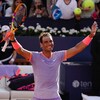 Un joueur de tennis lève les bras au ciel et sourit