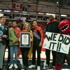 Plusieurs dignitaires, Pascal Siakam et la mascotte des Raptors prennent une photo avec l'affiche officialisant le record Guinness établi.