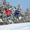 Deux athlètes de ski cross sautent pendant une course.