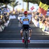Le cycliste belge, avec un casque rouge et un maillot aux couleurs de son pays, serre les poings lorsqu'il franchit le fil d'arrivée. 