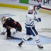 Un joueur de hockey lève les bras alors que la rondelle entre dans le filet.