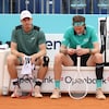 Deux joueurs de tennis sont assis sur un banc.