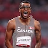 Un athlète avec des lunettes, de face, crie après sa victoire.