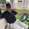 Homme assis dans une voiturette de golf.