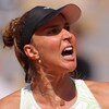 Une joueuse de tennis brandit le point et crie.