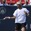 Un joueur de tennis effectue un coup droit pendant un match.