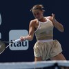 Une joueuse de tennis réalise un coup droit.