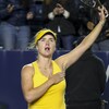 Une joueuse de tennis ukrainienne lève le bras dans les airs.