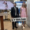 Une athlète prend la pose devant un écriteau qui porte son nom dans une école.