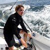 Elle regarde au loin sur son bateau, en mer.