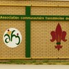 L'enseigne de l'Association communautaire fransaskoise de Moose Jaw sur un mur de brique jaune.