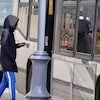 Un passager entre dans un autobus garé le long d'une rue.