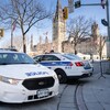 Deux voitures de police devant le Parlement à Ottawa. 
