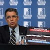 Éric Duhaime tenant une affiche en conférence de presse.
