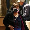 Une femme marche dans les rues de Regina en portant un masque.