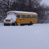 Des autobus scolaires ensevelis sous la neige.