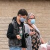 Des gens portant des masques à l'extérieur pendant la pandémie de la COVID-19 à Regina au printemps.
