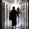 Un femme marche dans un corridor d'hôpital.