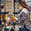 Une femme portant le masque marche au centre-ville d'Ottawa.