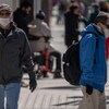 Deux hommes portant le masque marchent au centre-ville d'Ottawa.