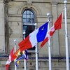 Les drapeaux du Canada, de l'Acadie et du Nouveau-Brunswick devant l'édifice de l'Assemblée législative