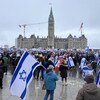 Des manifestants tenant des drapeaux israéliens devant le Parlement. 