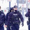 Quatre policiers de la GRC marchent sous la neige.