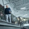 Le directeur général du Canadien Kent Hughes, en tenue décontractée, marche dans les gradins du centre sportif Bell à Brossard. 