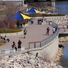 Des piétons marchent sur la promenade River landing à Saskatoon par une belle journée de printemps.