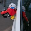 L'embout d'une pompe à essence inséré dans le réservoir d'une voiture.