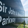 Un panneau indiquant la promenade Sir-John-A.-Macdonald avec la rivière des Outaouais en fond.