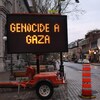 Un panneau numérique de limite de vitesse installé en bordure de la rue Saint-Jean affiche le message « GENOCIDE A GAZA ». 