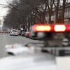 Des gyrophares de police flous en premier plan d'une scène de crime.