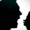 La silhouette d'un homme qui crie vers un téléphone dans sa main.