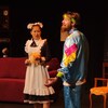 Deux personnes sur scène pendant une pièce de théâtre, en costume.