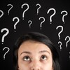 Une jeune femme confuse et des points d'interrogation