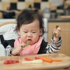 Un bébé asiatique mange des aliments solides sur sa chaise haute.