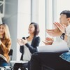 De jeunes employés d'entreprise applaudissent en souriant lors d'une réunion.