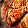 Gros plan sur une part de pizza à la tomate et au fromage.