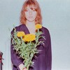 Une femme tient un bouquet de fleurs.