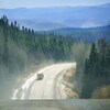 Un camion lourd circule dans les nuages de poussière sur la route 389.