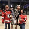 Le hockeyeur  Charle Truchon tenant la Coupe Memorial dans ses bras avec son père et sa mère.
