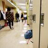 Des élèves marchent dans un couloir.
