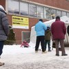 Des gens font la queue devant une clinique de dépistage de la COVID-19, à Montréal.