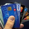 Une personne tient dans sa main diverses cartes de crédit.