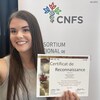 Daphné Bélanger est souriante en tenant un certificat offert par le Consortium National de Formation en Santé.