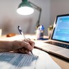 Une personne remplit sa déclaration de revenus sur papier.
