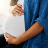 Une femme enceinte se tient le ventre.